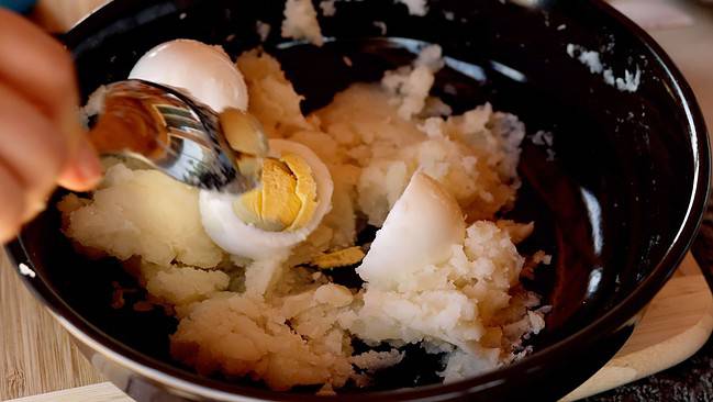 Adding eggs to cooked potatoes